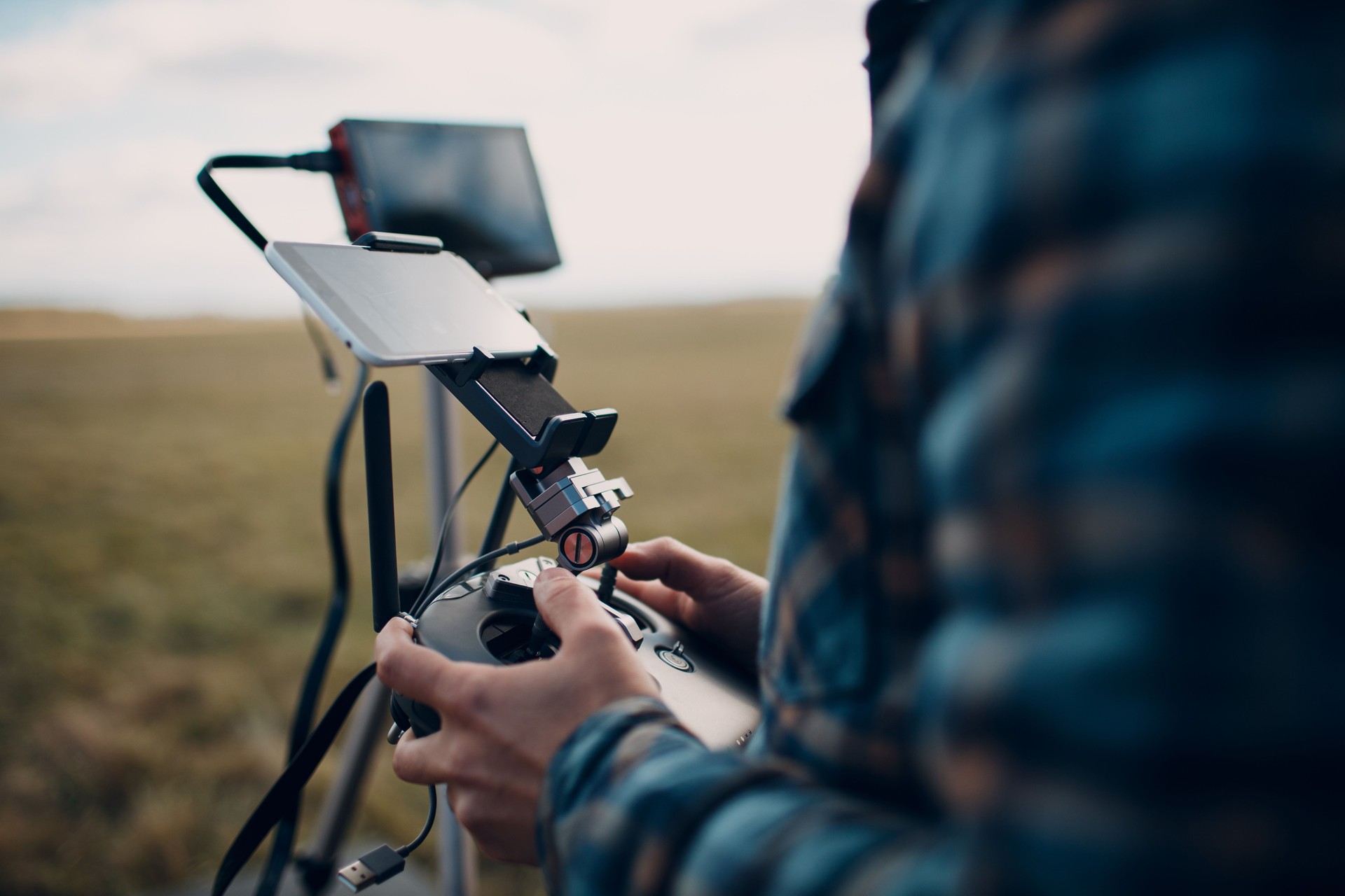 Man pilot controlling quadcopter drone with remote controller pad